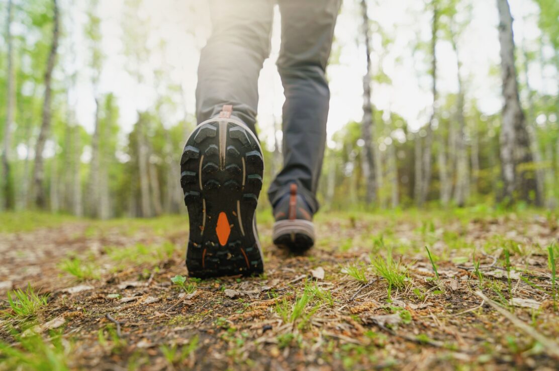 A close-up of a person walking in the woods.