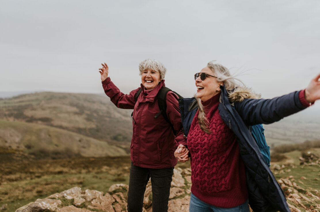 Two women laughing together during a hike.