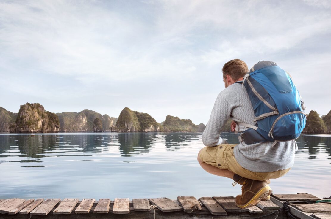 Traveller crouching on a jetty.