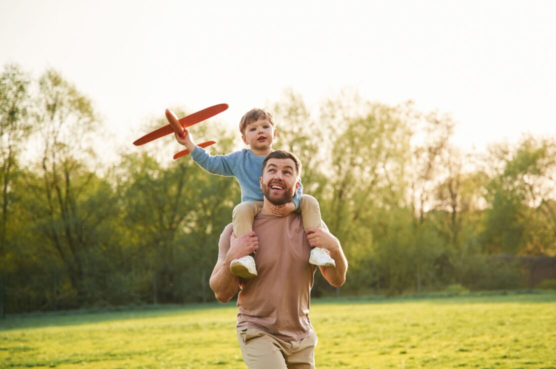 A father with a child sitting on his shoulders.