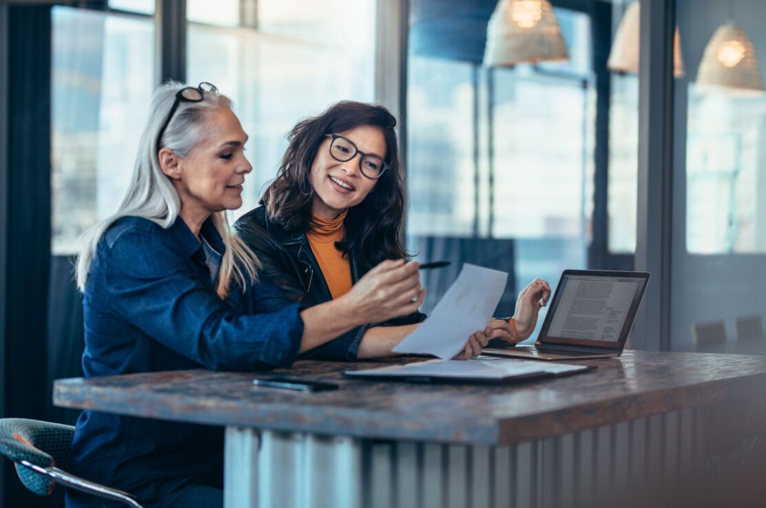 A woman talking to a colleague in an office.