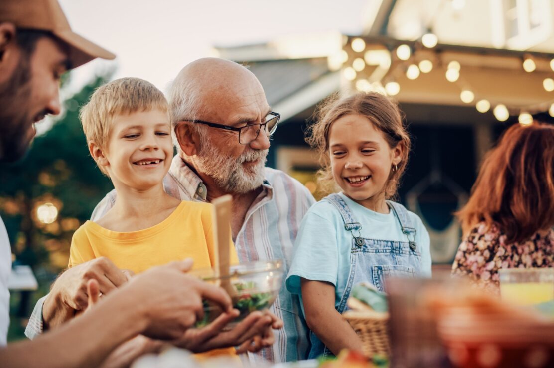 A grandfather laughing with his grandchildren.